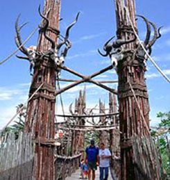 Two people standing in front of a wooden structure.