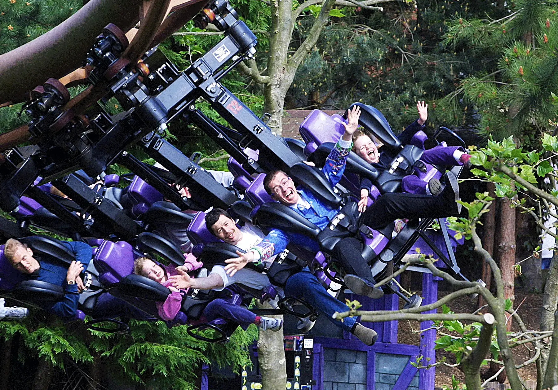 A group of people riding on the top of a roller coaster.